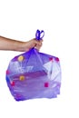 Hand hold purple plastic garbage bag with used PET bottles isolated on white Royalty Free Stock Photo