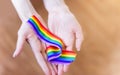 hand hold a rainbow of LGBT tapes on a LIGHT background. Copy space The concept of homosexuals and LGBT people.