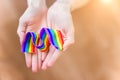 Hand hold a rainbow of LGBT tapes on a LIGHT background. Copy space The concept of homosexuals and LGBT people.