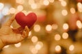 Hand hold red heart shape pillow with beautiful bokeh by candle light. Royalty Free Stock Photo