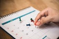 hand hold red push pin to mark date on calendar with vignette Royalty Free Stock Photo