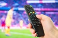 Hand hold remote control in front of tv Royalty Free Stock Photo