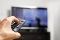 Hand hold remote control in front of tv Royalty Free Stock Photo