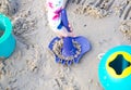 Hand hold shovel toy on sand beach in summer vacation concept