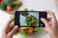 Hand hold smartphone woman takes photo healthy food for blog,photographer food Royalty Free Stock Photo