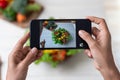 Hand hold smartphone woman takes photo healthy food for blog,photographer food Royalty Free Stock Photo