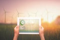 hand hold tablet and wind turbine at sunrise Royalty Free Stock Photo