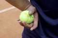 Hand hold Tennis ball on clay court. Red clay tennis court. Sand on a tennis court. The tennis court on clay. Tennis Clay Court Royalty Free Stock Photo
