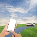 hand hold and touch screen smart phone with airplane in the sky, dumper truck on road blue sky background,open high season travel Royalty Free Stock Photo