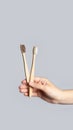 Hand hold bamboo eco tooth brush. Grey background Royalty Free Stock Photo