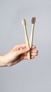 Hand hold bamboo eco tooth brush. Grey background Royalty Free Stock Photo