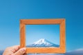 hand hold wood frame and focus Fuji mountain on background.