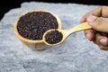 Hand hold a wooden spoon, riceberry on wooden spoon