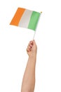 A hand holdiing the flag of Ireland against a white background