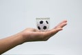 Hand holding acrylic football cube against white background