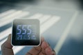 Hand holding air quality monitoring device shown high number of dust at carpark of building in the morning with smoke effect Royalty Free Stock Photo