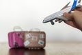 Hand holding airplane with luggage on the background Royalty Free Stock Photo