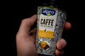 Hand holding Alpro plant based barista latte caffe or coffee. Ethiopian coffee with plant based soya and caramel milk.