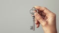 Hand Holding Antique Silver Key on Neutral Gray Background Symbolizing Security and Access Royalty Free Stock Photo