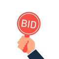 Hand holding auction paddle. Royalty Free Stock Photo