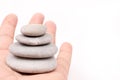 Hand holding balanced grey stones over white background Royalty Free Stock Photo