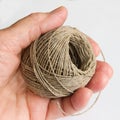 Hand holding a ball of natural hemp twine, ready to wrap a consignment