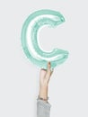 Hand holding balloon letter C Royalty Free Stock Photo