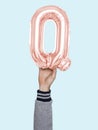 Hand holding balloon letter Q Royalty Free Stock Photo