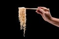 Hand holding bamboo chopsticks and fork over instant noodles Royalty Free Stock Photo