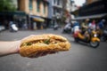 Hand holding Banh Mi sandwich on street in Hanoi Royalty Free Stock Photo