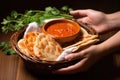 hand holding a basket of naan bread next to rogan josh