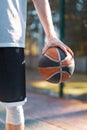 Hand holding basketball ball, close-up of male professional basketball player outdoors in summer Royalty Free Stock Photo