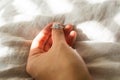 Hand Holding Beautiful Silver Shiny Diamond Ring on Grey Linen Fabric Royalty Free Stock Photo