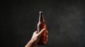 A hand holding a beer bottle over dark background, AI Royalty Free Stock Photo