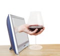 Hand holding big glass with red wine leans out TV Royalty Free Stock Photo