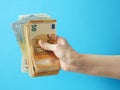 Hand holding big stack of dollar money on blue background. money cash Royalty Free Stock Photo