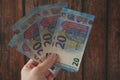 Hand holding of big stack of euro different money on wooden background. money cash Royalty Free Stock Photo