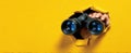 The Hand Holding Binoculars Through a Hole in a Yellow Wall AI generated image Royalty Free Stock Photo