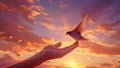 Hand holding a bird on sunset sky background. Bird in the hand Royalty Free Stock Photo