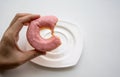 Hand holding bite donut ring with strawberry flavor glaze coating Royalty Free Stock Photo