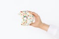 Hand holding bitten delicious donut on background of white wall in room. Birthday party. Diet Royalty Free Stock Photo