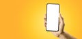 Hand holding black cellphone with blank screen and modern frame less design on yellow background. smartphone showing white blank Royalty Free Stock Photo