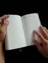 hand holding black cover notebook black background Royalty Free Stock Photo