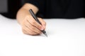 Hand holding black fountain pen writing on white paper Royalty Free Stock Photo
