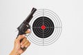 Hand holding black gun with shooting target background Royalty Free Stock Photo