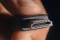 Hand holding black HDMI cable. Man's hand holds a HDMI Connector. Closeup HDMI cable.