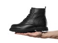 Hand holding black leather shoes with laces. Close up. Isolated on a white background Royalty Free Stock Photo