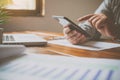 Hand holding black mobile phone with blank white  in desk work for home Royalty Free Stock Photo