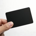 Hand holding a black rectangular object against a white background Royalty Free Stock Photo