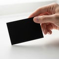 A hand holding a black rectangular object against a white background Royalty Free Stock Photo